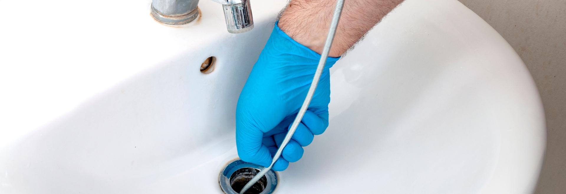 HVAC professional cleaning a drain.