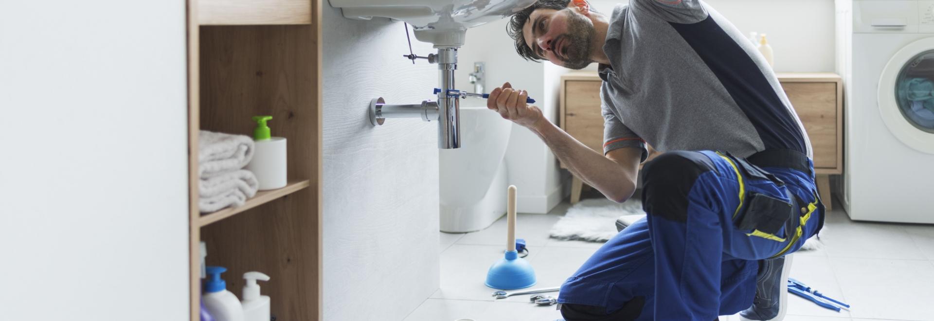 Professional Plumber Fixing a sink pipe.