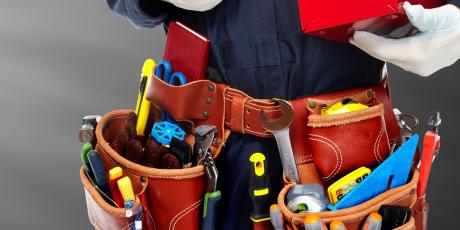 Plumbing and pipefitting professional standing with his tools.