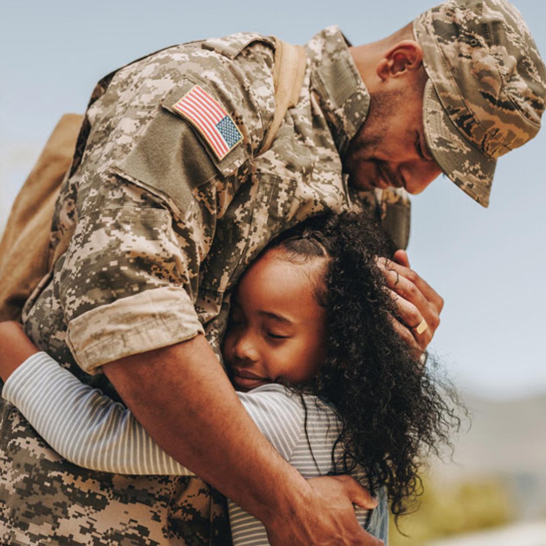 military man hugging a child